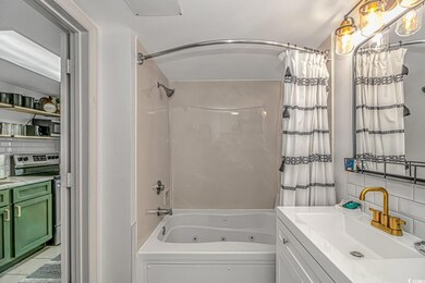 Bathroom featuring vanity, backsplash, and shower 