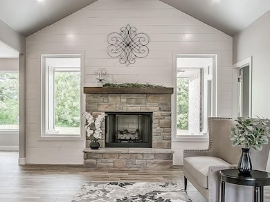 Gorgeous Shiplap Wall and Large Windows encase this Stone Gas Fireplace.