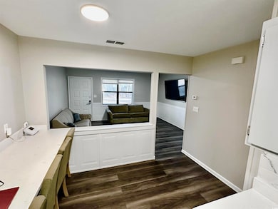 Interior space featuring dark wood-style floors, l