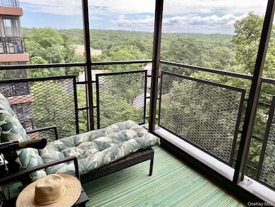 Balcony with an outdoor living space and a view of trees