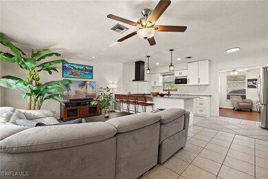 Living room with light tile patterned floors, a te