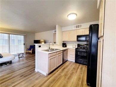 Kitchen with visible vents, a sink, light wood-typ