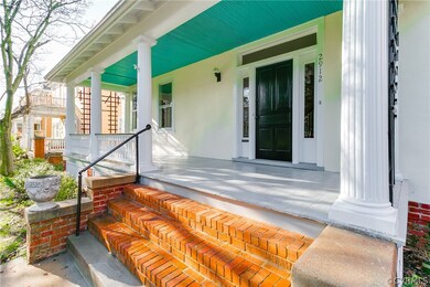 This wide front porch is perfect for rocking chairs or a porch swing while enjoying the neighborhood. A transom and side windows adorn the front door for extra sunlight in this home's entryway.