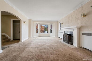 Unfurnished living room with ornamental molding, arched walkways, a premium fireplace, carpet floors, and radiator