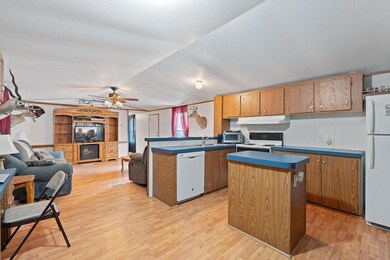 Kitchen with dark countertops, white appliances, 