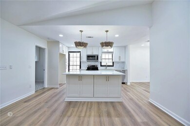 Kitchen with white cabinetry, decorative backsplas