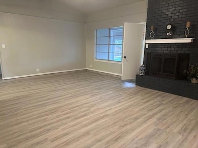 Unfurnished living room featuring ceiling fan, a f