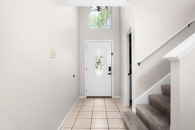 Foyer with stairs, light tile patterned floors, a