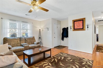 Living room featuring ceiling fan and light hardwood / wood-style floors