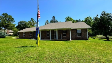 Ranch-style home with a front yard and brick siding