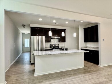 Kitchen with light wood-type flooring, an island w