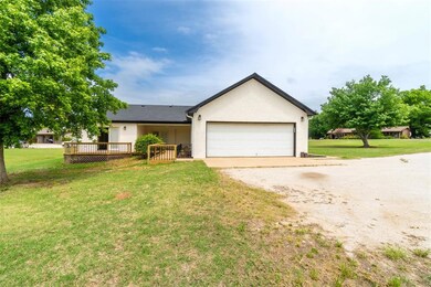 Single story home with a deck, a garage, and a fro