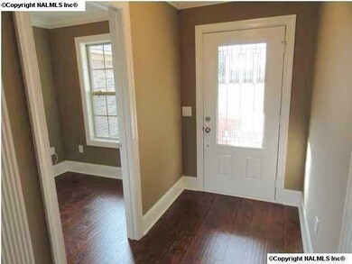 Inviting foyer with wood floors and study off to the left.