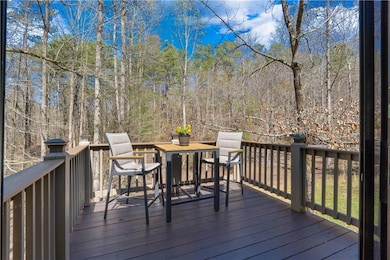 Wooden deck with outdoor dining area and a wooded 