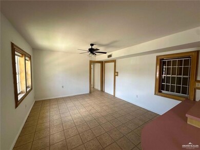 Tiled spare room with a ceiling fan and baseboards