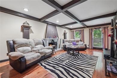 Living area featuring hardwood floors, beamed ceil