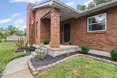 Entrance to property with a yard, brick siding, and a porch