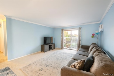 Carpeted living area featuring ornamental molding and baseboards