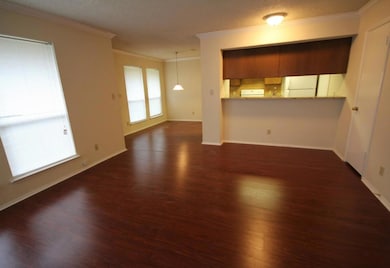 Unfurnished living room featuring crown molding, dark wood-type flooring, and a textured ceiling