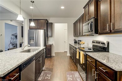 You will love this beautiful kitchen! Spacious kitchen features granite countertops, tile backsplash, stainless appliances (refrigerator remains), pantry, and beautiful floors that compliment the aesthetic touches.