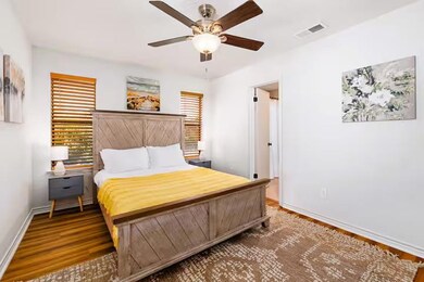 Bedroom with wood finished floors, baseboards, an