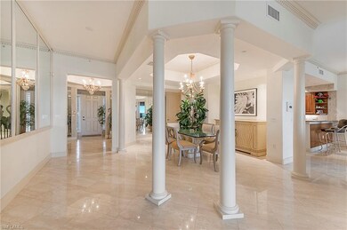 Open floor plan with stately columns and marble fl