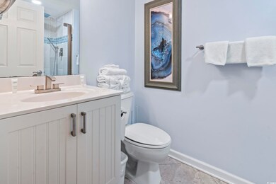 Bathroom with tile patterned flooring, vanity, toilet, and a tile shower