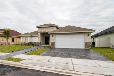 Prairie-style house with a shingled roof, a front yard, concrete driveway, and stucco siding