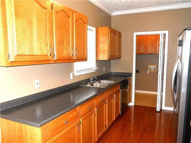Sparkling kitchen has hardwood floors, plus the utility room at the end.