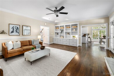 Living room featuring ceiling fan, dark hardwood f