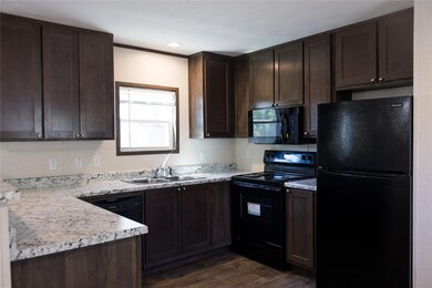 Kitchen featuring dark brown cabinets, black appli
