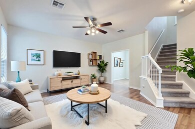 Living room featuring stairs, ceiling fan, visibl