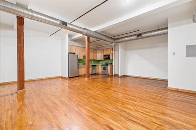 Open floor plan living room, dining room and kitchen with 10+ foot ceilings, exposed wood beams and ductwork