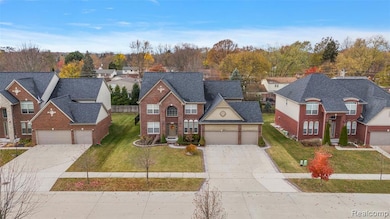 Traditional-style house with a residential view, brick siding, concrete driveway, and a front yard