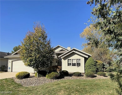 View of front facade featuring concrete driveway, a front yard, a garage, and a chimney