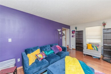 Living room with laminate-style floors and a textured ceiling