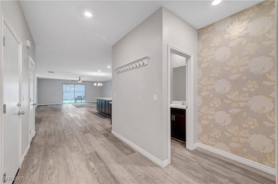 Corridor with wallpapered walls, light wood-style