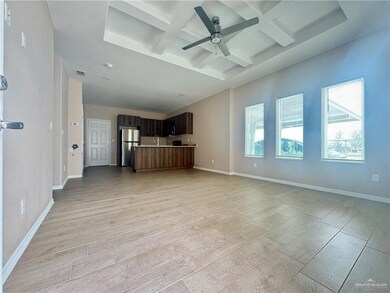 Unfurnished living room featuring ceiling fan, light wood-style floors, visible vents, and coffered ceiling