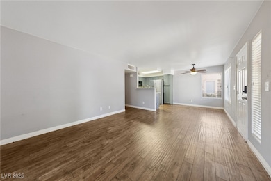 Unfurnished living room with a ceiling fan and dar