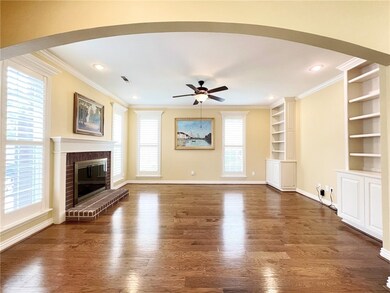 Living room with brick fireplace, built ins and pl