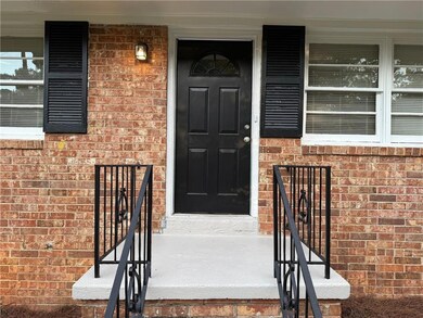 Doorway to property with brick siding and covered porch