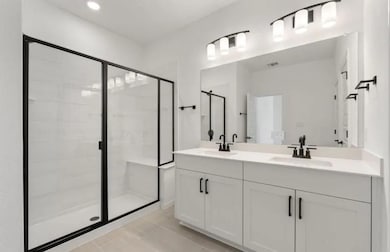 Full bath featuring a stall shower, double vanity