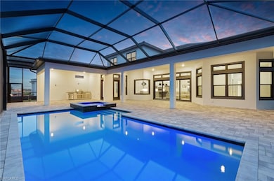 View of pool featuring a pool with connected hot tub, a patio area, and a lanai