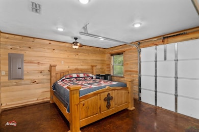 Bedroom with electric panel and wooden walls