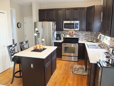 Kitchen has refinished hardwood floors, an island 