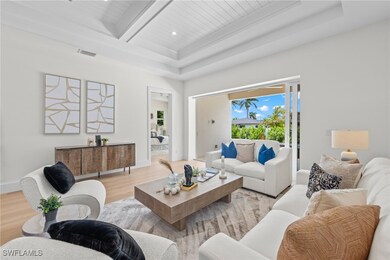 Living room with a tray ceiling, beamed ceiling, w