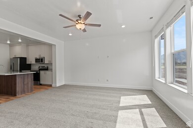 Unfurnished living room featuring light colored carpet, recessed lighting, and a ceiling fan
