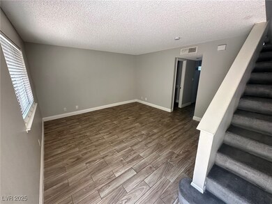 Empty room featuring dark wood-type flooring, stai