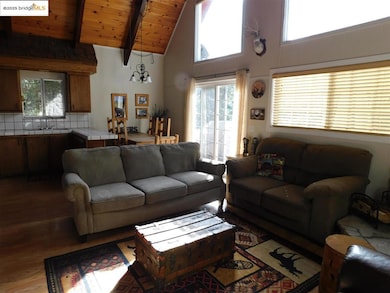 Living room featuring sink, hardwood / wood-style flooring, wooden ceiling, beam ceiling, and high vaulted ceiling