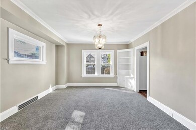 Light and bright dining room with three windows, corner cupboard and original wood floors under newly installed carpet